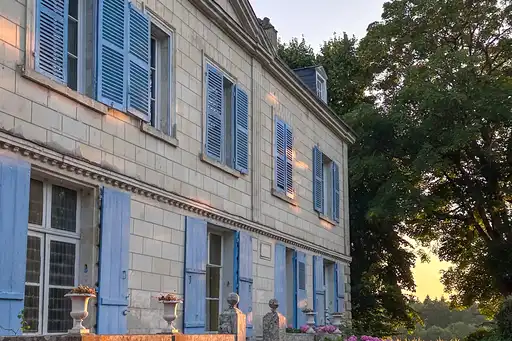 Ein Herrenhaus im Loiretal mit blauen Fensterläden und goldenem Abendlicht