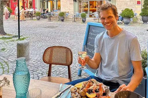Ein Mann sitzt vor einem Meeresfrüchte-Teller in einem Restaurant in der Normandie