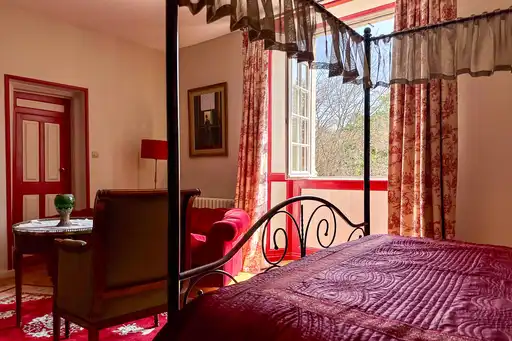 Ein rotes Bett im Gästezimmer einer Unterkunft in der Normandie