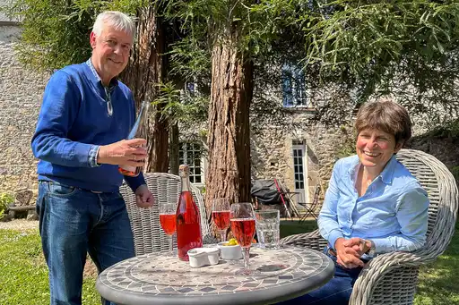 Ein Mann schenkt einer Frau ein Glas Cidre ein