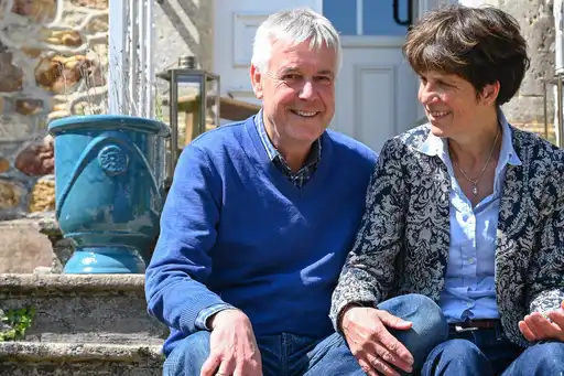 Ein Paar sitzt auf einer Treppe vor einem Haus