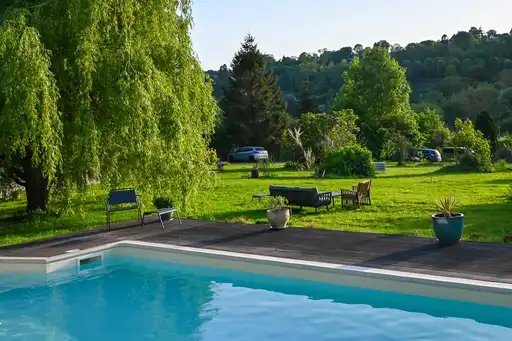 Garten mit Bänken und Pool in der Normandie