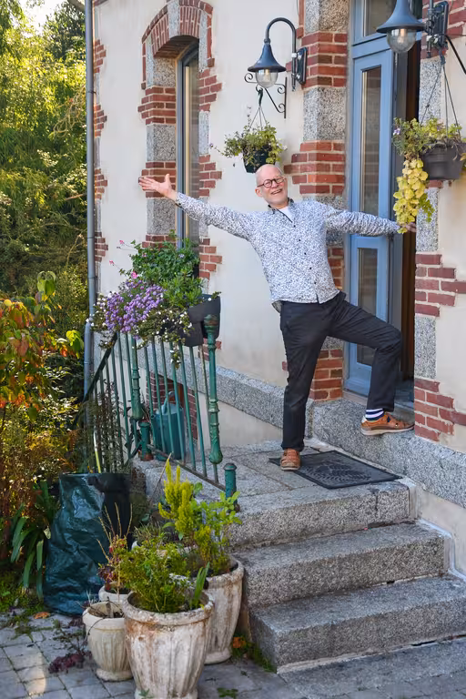 Der Gastgeber des Hauses am Flussufer in der Bretagne steht einladend vor dem Eingang