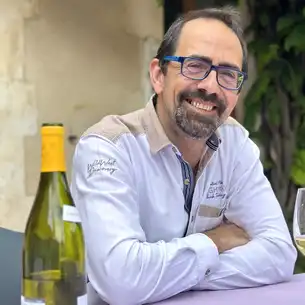 Der Gastgeber der alten Poststation sitzt an einem Tisch mit einem Glas Wein