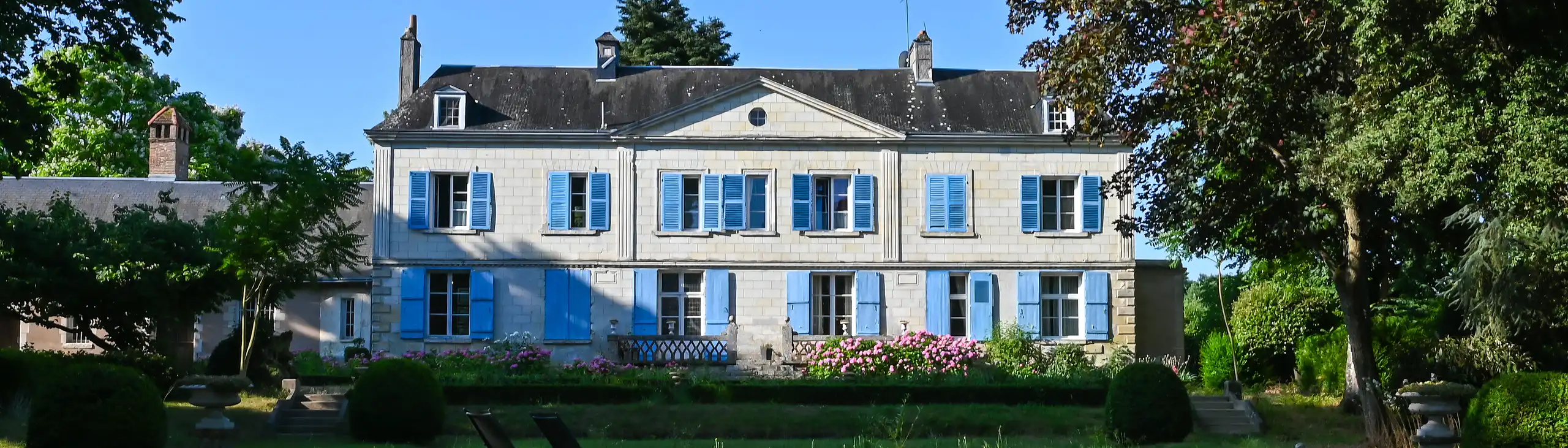 Ein Herrenhaus mit blauen Fensterläden im Morgenlicht