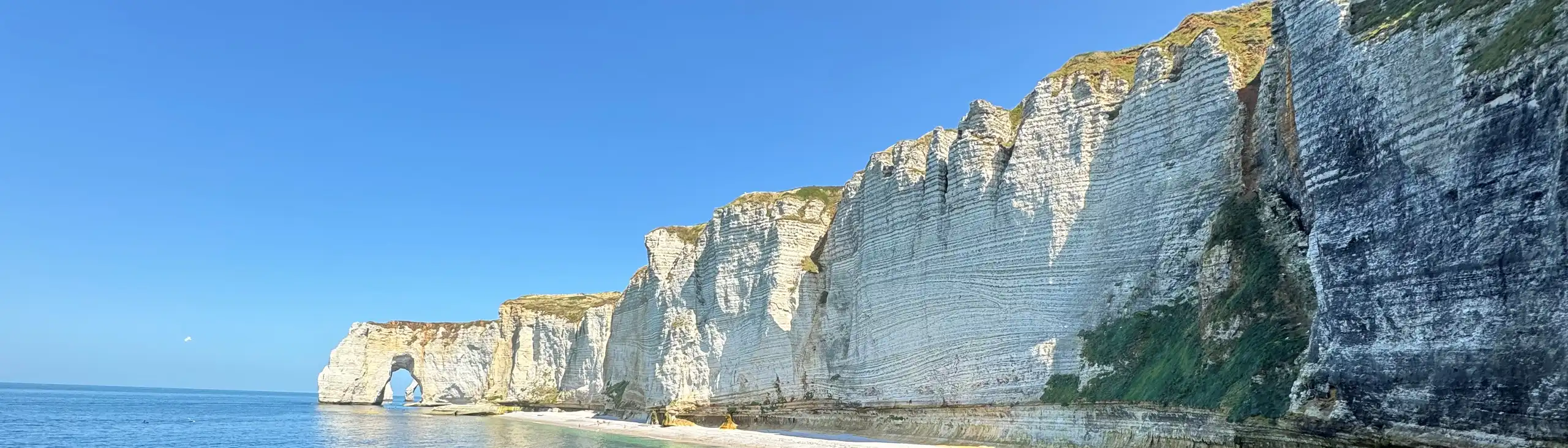 Kreidefelsen in Étretat im Sonnenlicht vor Meer