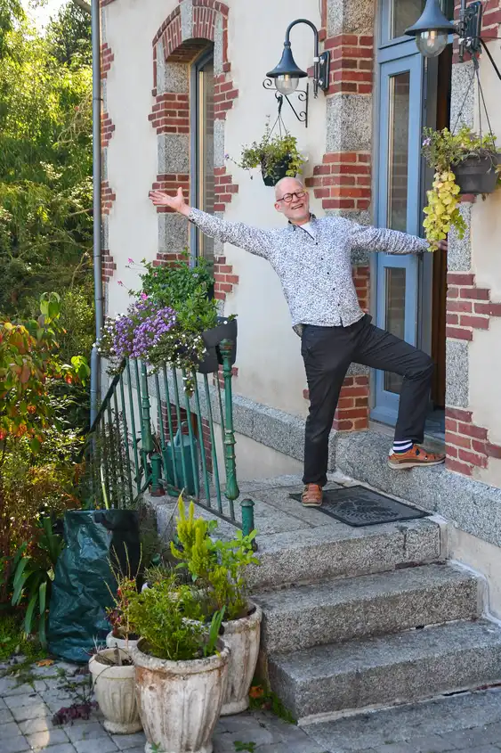 Der Gastgeber des Hauses am Flussufer in der Bretagne steht einladend vor dem Eingang