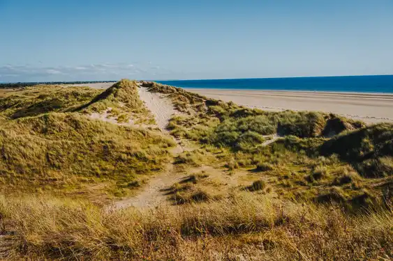 Große teilweise mit Gras bewachsene Dünen am Strand in der Normandie