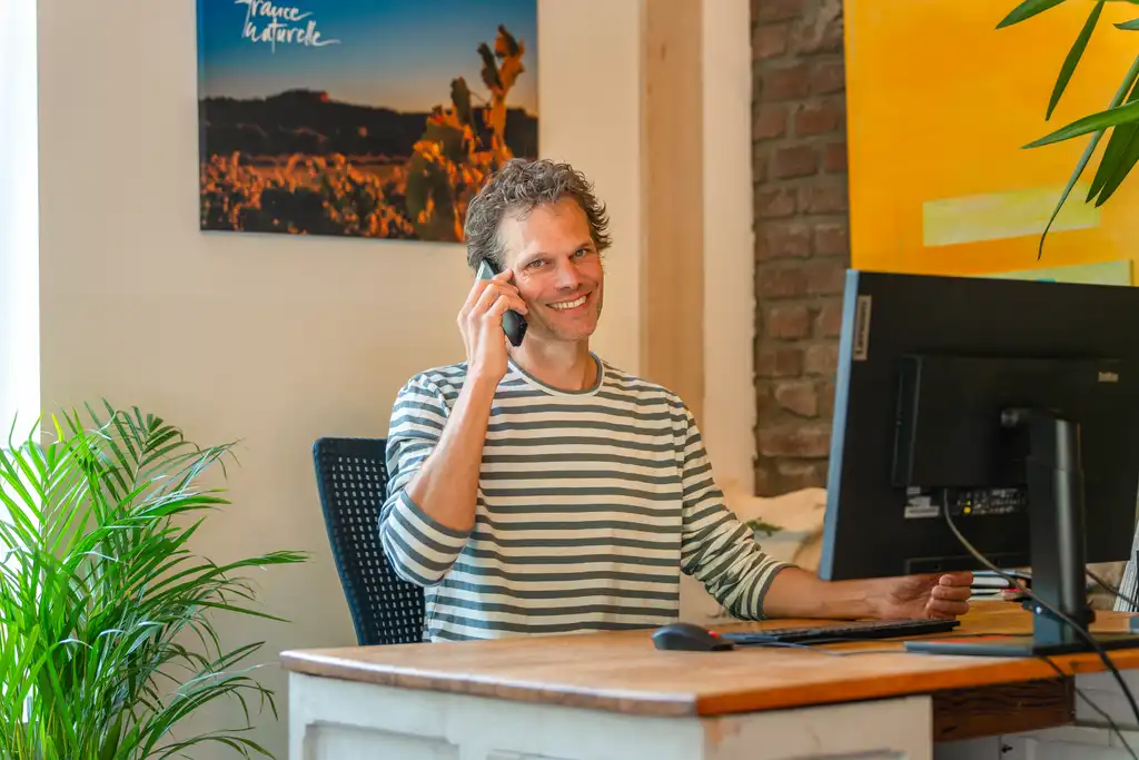 Ein Mann vor einem Computer, der telefoniert