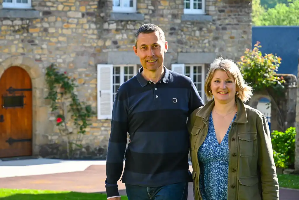 Gastgeber stehen im Garten vor dem Landhaus in der Normandie