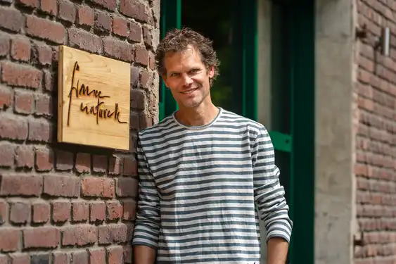 Thomas vor dem Büro an einer Wand gelehnt