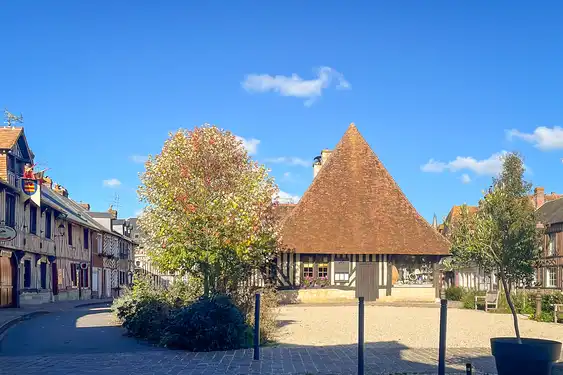 Ein schönes Fachwerkhaus auf einem Platz in einem Dorf in der Normandie mit einem großen Dach