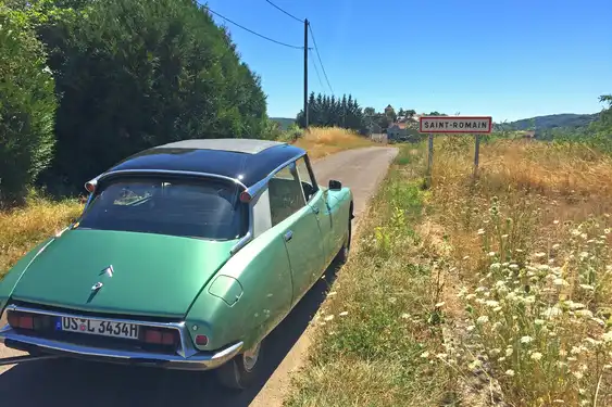 Ein Oldttimer fährt über eine Landstraße im Burgund