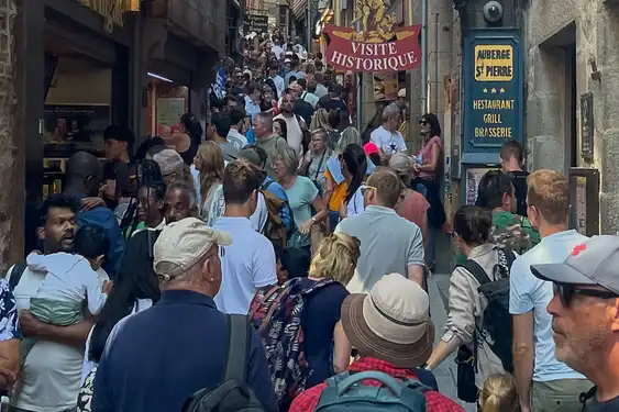 Eine Gasse mit Geschäften und Restaurants auf Mont Saint Michel mit vielen Touristen