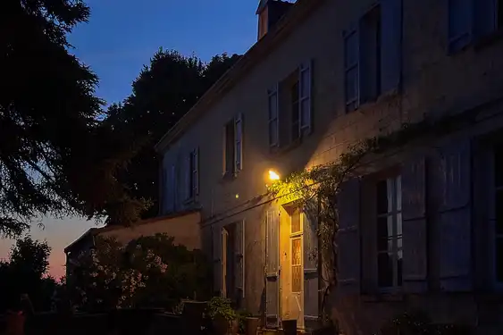 Der atmosphärisch beleuchtete Eingang des Weinguts in der Loire nach Sonnenuntergang