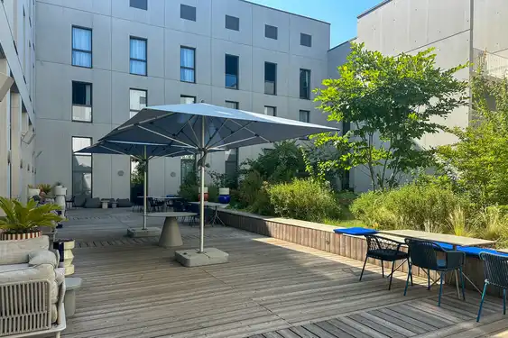 Terrasse des Hotels, mit ein paar Bäumen und diversen Sitzmöglichkeiten