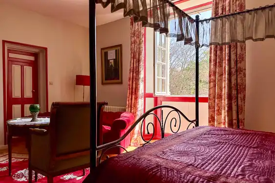 Ein rotes Bett im Gästezimmer einer Unterkunft in der Normandie