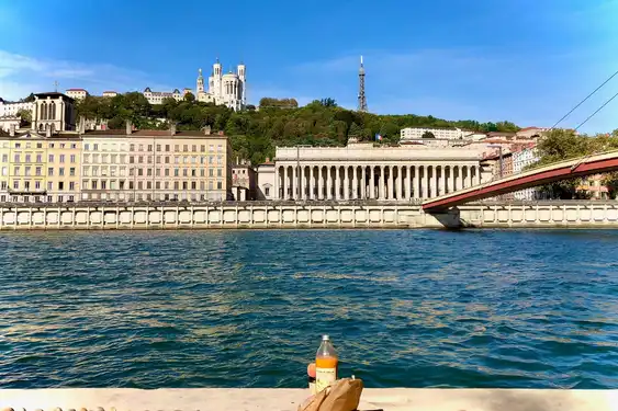 Ein Orangensaft und eine Brötchentüte am Ufer der Saone in Lyon