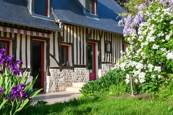Ein uriges Fachwerkhaus umrahmt von Blumen in der Normandie