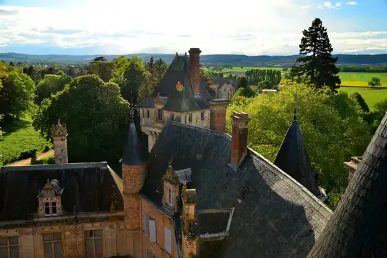 Das Dach des Schlosses im Burgund mit der schönen Landschaft im Hintergrund
