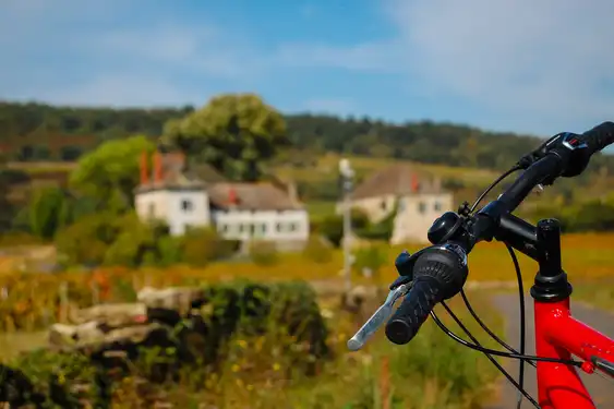 Fahrrad auf einem Feldweg im Burgund mit Häusern im Hintergrund