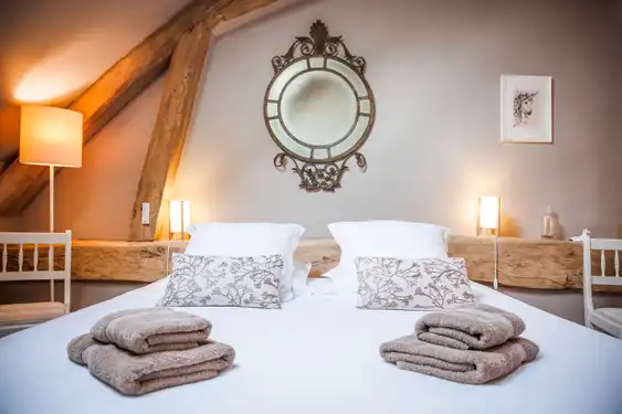 Ein rustikales Gästezimmer im Gutshof in der Loire mit sorgfältig gefalteten Handtücher auf dem Bett