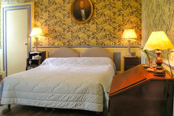 Ein Zimmer mit antiker Tapete und antiken Möbeln in gemütlichem Licht