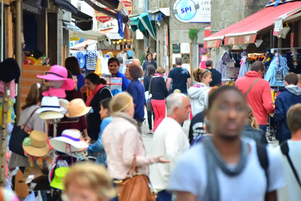 Touristen auf einem Markt in der Normandie
