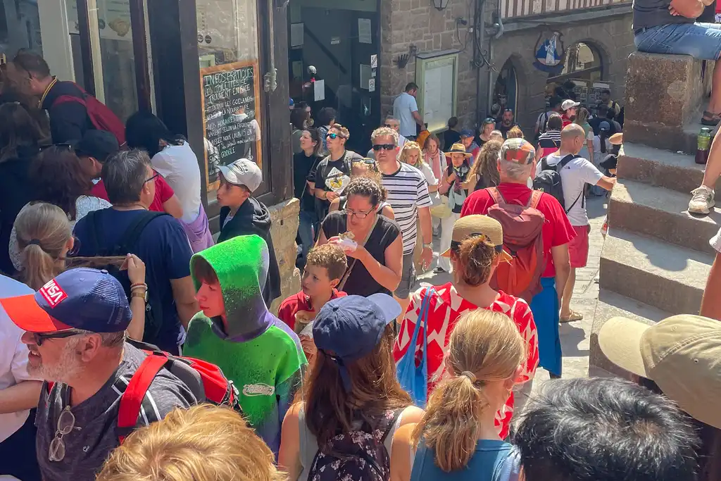 Viele Touristen stehen vor einem Laden auf Mont Saint Michel in der Normandie