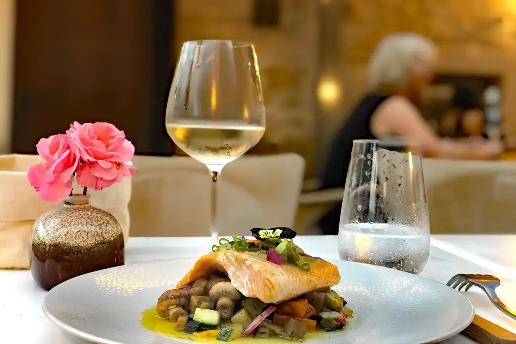 Ein appetitliches Fischgericht mit einem Glas Wein in einem vornehmen Restaurant im Burgund