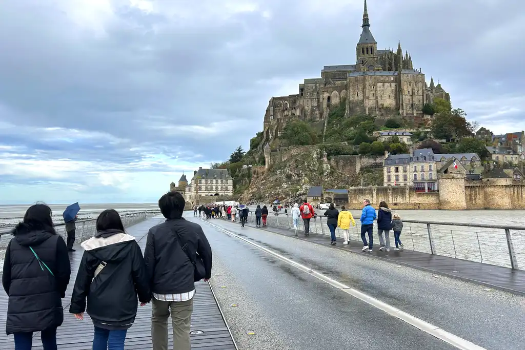 Touristen auf der Brücke nach Mont-Saint-Michel in der Normandie