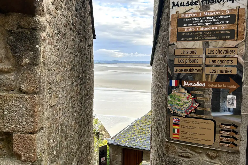 Eine kleine Gasse auf dem Mont-Saint-Michel in der Normandie mit Ausblick auf das Meer