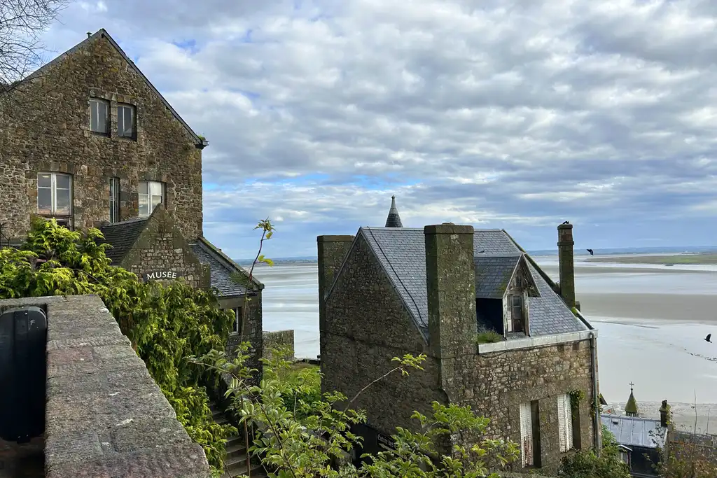 Charmante Häuser auf Mont-Saint-Michel mit dem Meer im Hintergrund
