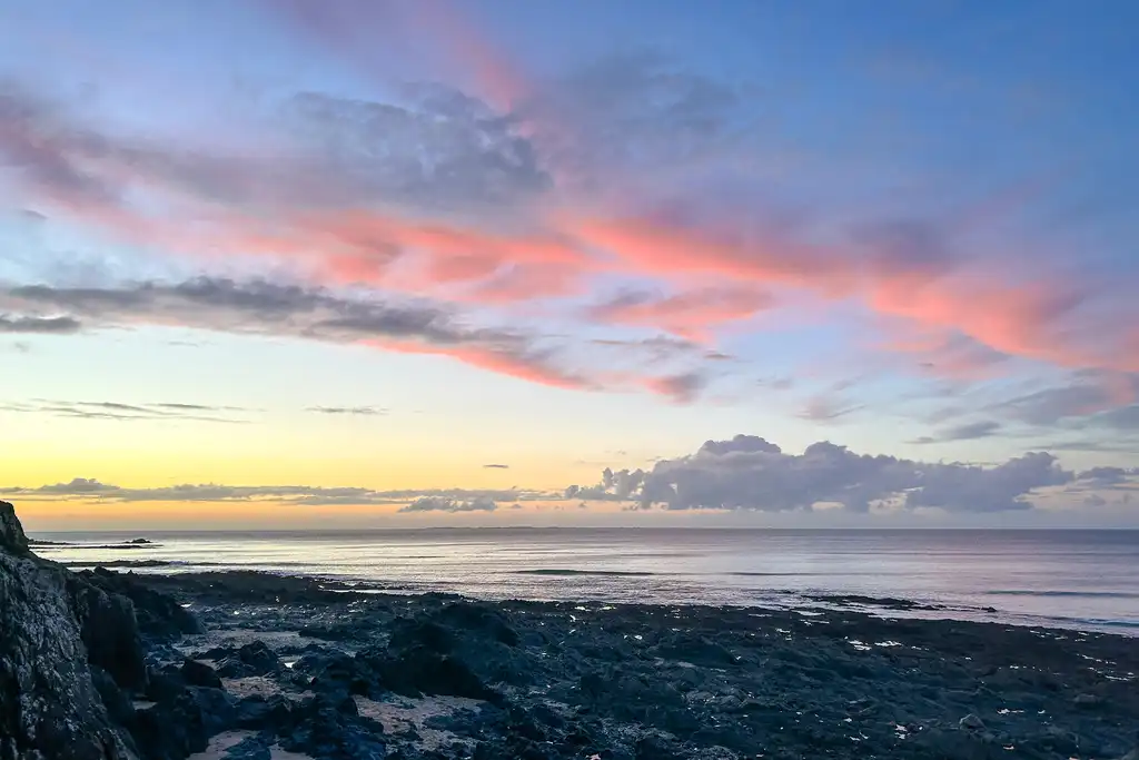 Sonnenuntergang am Strand in der Normandie mit einem orange verfärbten Himmel
