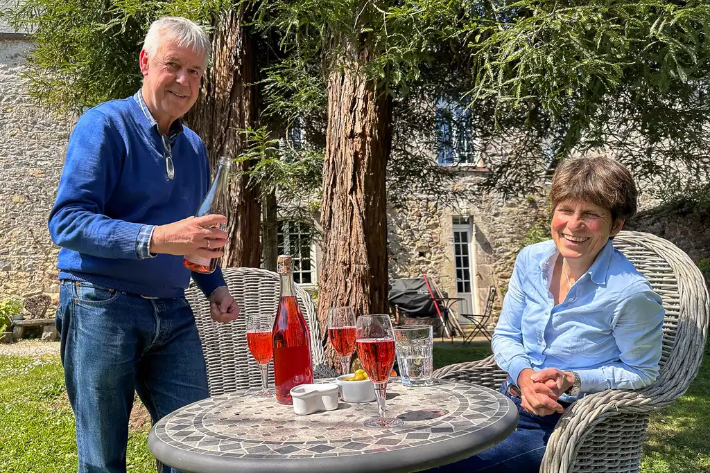 Ein Mann schenkt einer Frau ein Glas Cidre ein