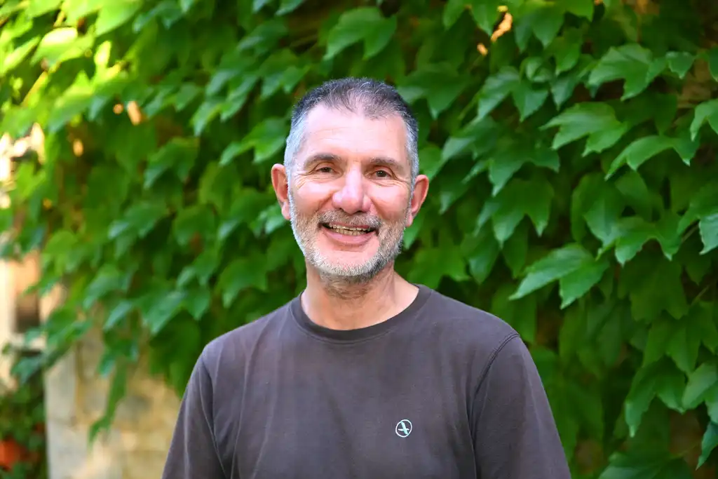 Der Gastgeber des Landguts im Burgund steht lächelnd vor dem Haus