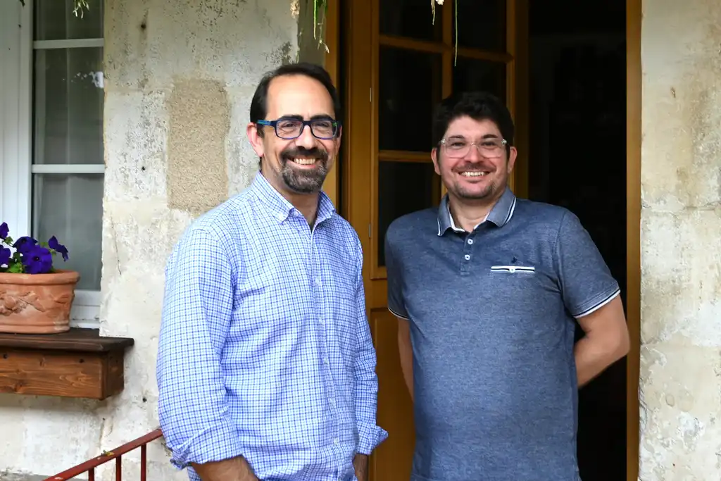 Die Gastgeber der alten Poststation im Burgund stehen lächelnd im Eingang