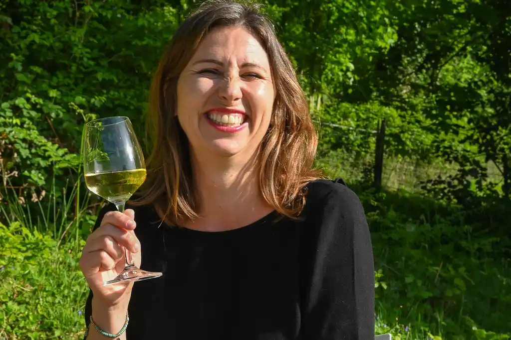 Die Gastgeberin hält ein Weinglas in der Hand und lächelt in der Normandie
