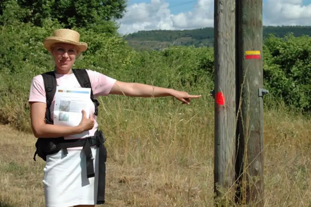 Eine Frau bei einer Wanderung zeigt auf eine Markierung im Burgund