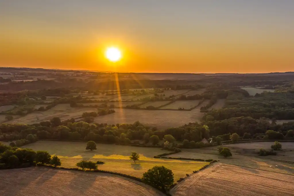 Drohnenaufnahme von Feldern im Burgund bei einem malerischen Sonnenuntergang