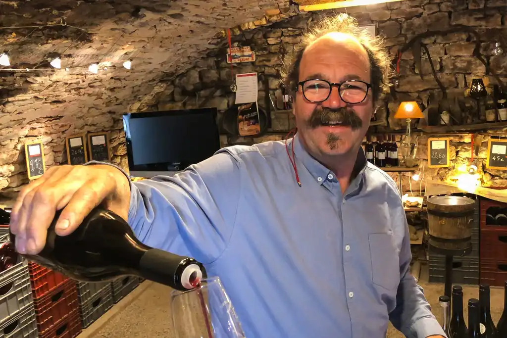 Der Winzer schenkt Wein ein in einem Weinkeller im Burgund