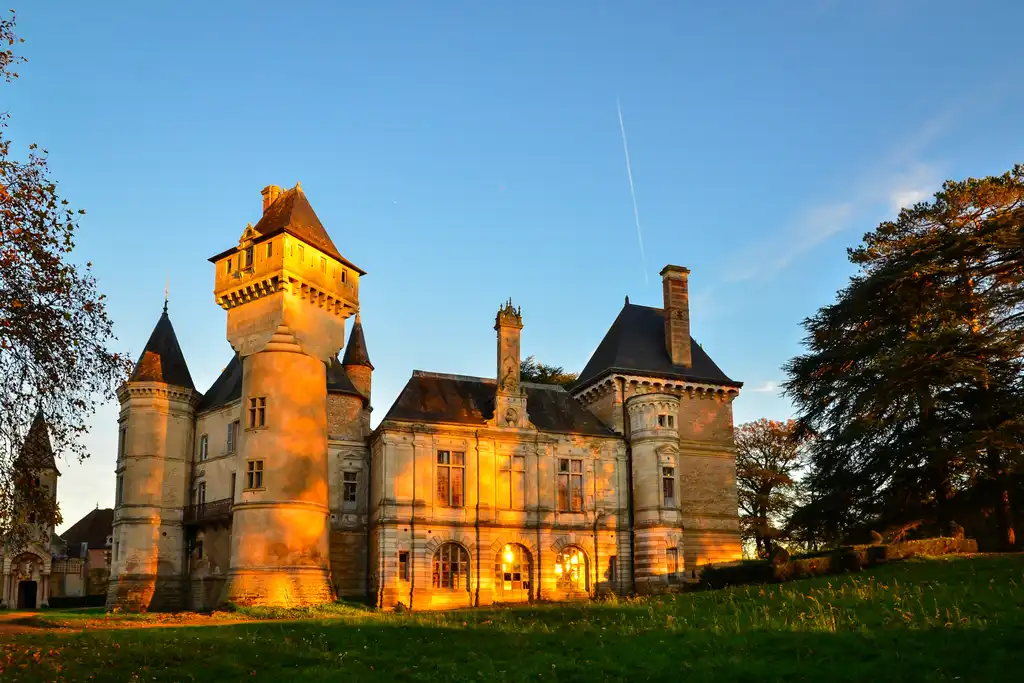 Das Schloss im Burgund das atmosphärisch von der Abendsonne beschienen wird