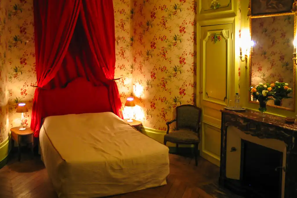 Ein Zimmer im Schloss im Burgund mit edler Einrichtung und floraler Wandtapete