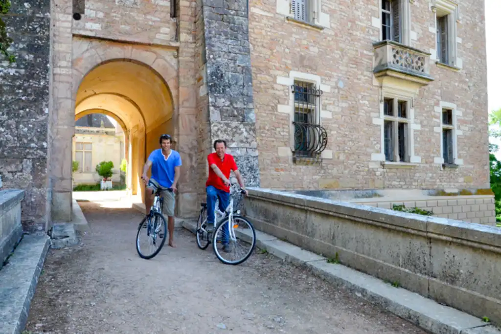 Zwei Männer auf Fahrrädern vor einem Torbogen im Burgund