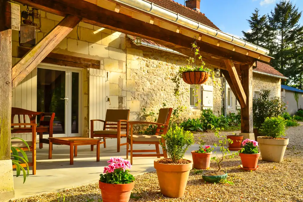 Die schöne und gemütliche Terrasse des Gutshofs in der Loire mit vielen Blumen