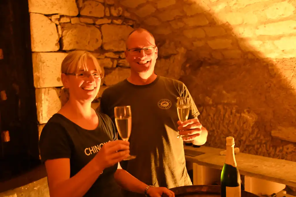 Die Gastgeber des Tuffsteinhauses in der Loire mit Weingläsern in der Hand