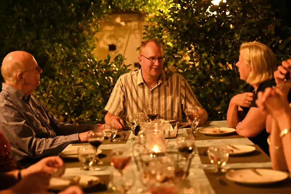 Der Gastgeber sitzt am Esstisch im auf der Veranda des Tuffsteinhauses in der Loire