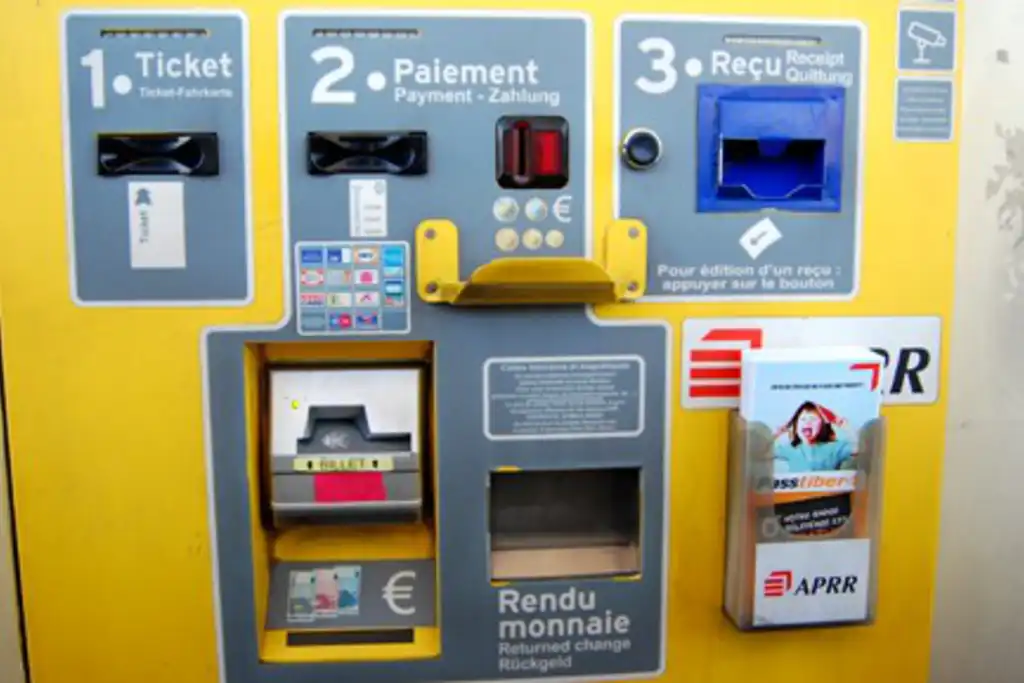 Ein gelber Mautautomat an einer Autobahn mit verschiedenen Zahlungsmöglichkeiten