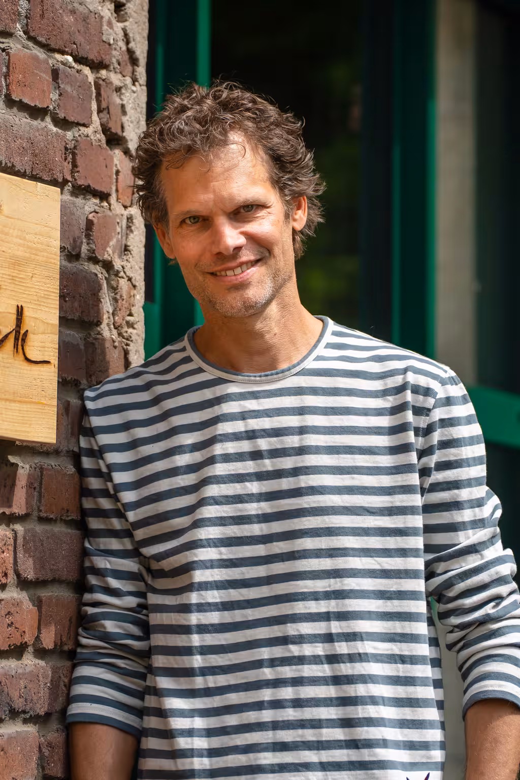 Thomas vor dem Büro an einer Wand gelehnt