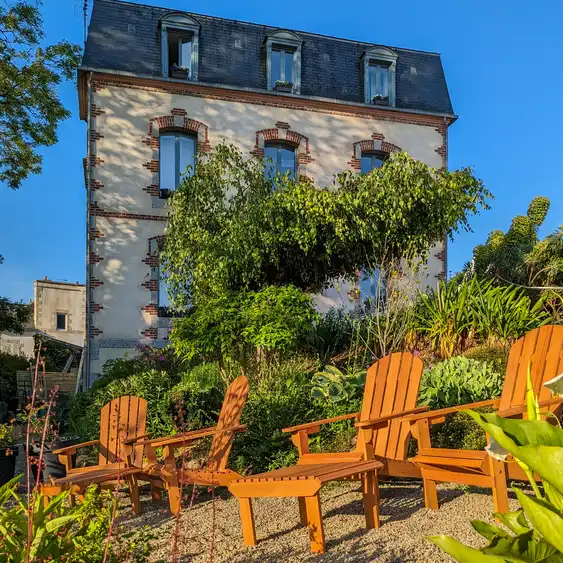 Gemütliche Liegestühle im gepflegten Gartens des Hauses am Flussufer in der Bretagne